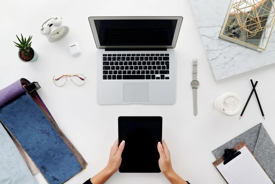 Un wireframe de site web affiché sur l’écran d’un MacBook posé sur un bureau de bureau.